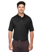Tall male model wearing Core365 Origin Performance Piqué Polo in black, designed with moisture-wicking fabric and athletic fit.