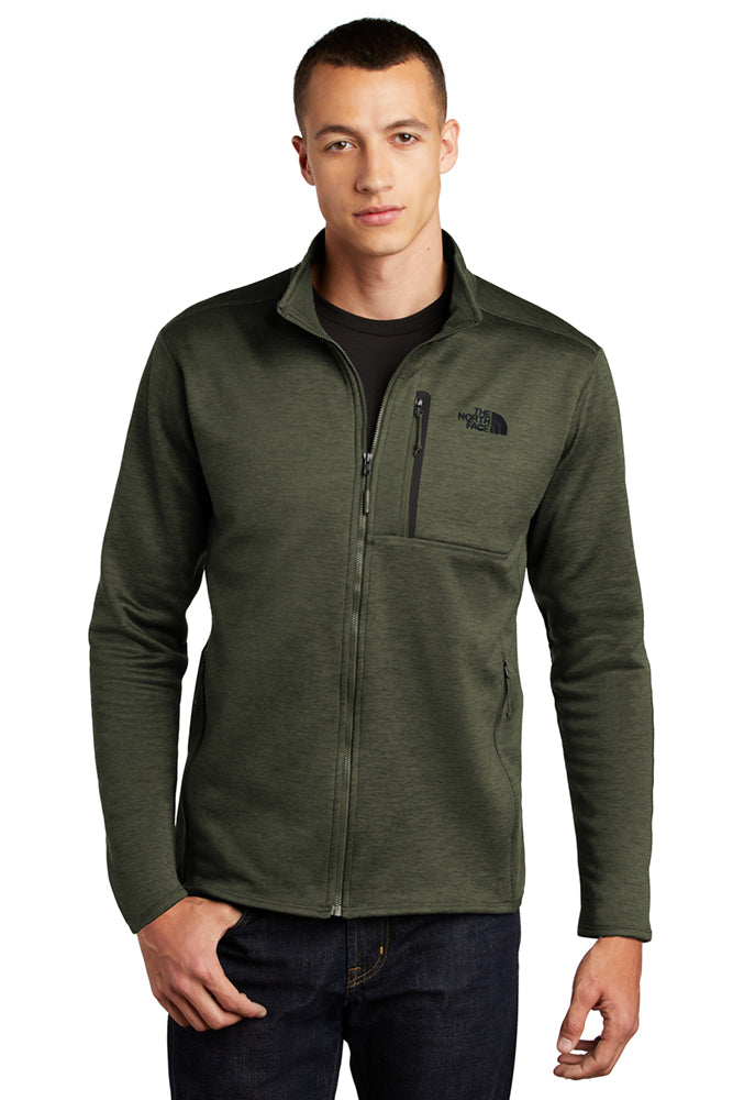 Male model wearing The North Face Skyline Full-Zip Fleece Jacket in forged iron heather, featuring a streamlined fit, full front zipper, and embroidered chest logo.