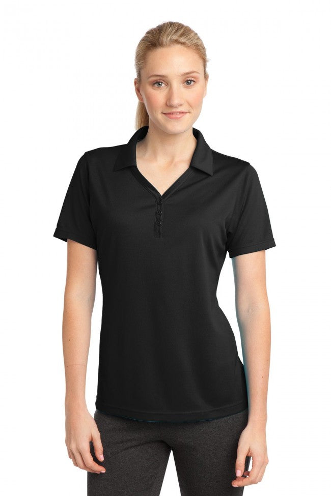 Female model wearing Sport-Tek Women's PosiCharge Micro-Mesh Polo in black, featuring moisture-wicking fabric and open placket design.
