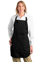  Model wearing full-length black custom embroidered apron with front pockets, adjustable neck strap, and clean professional look.