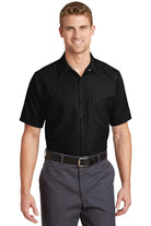  Male model wearing Red Kap black industrial short sleeve work shirt with button-front closure and dual chest pockets.